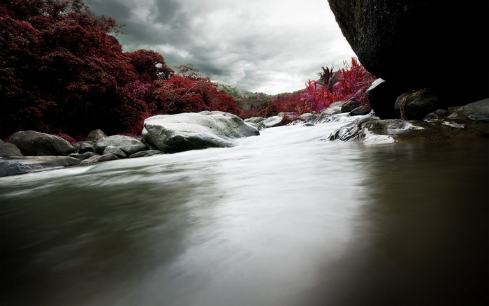 River flowing through rocks with red foliage