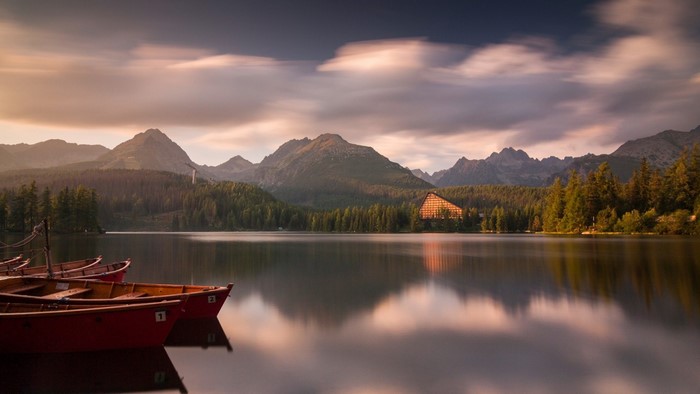 Boats on a lake with mountains at sunset