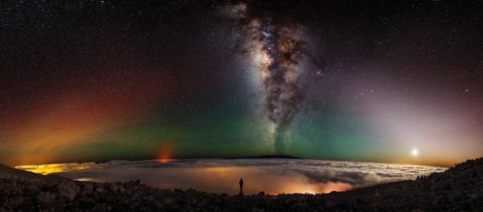Milky Way and Aurora over clouds with silhouette