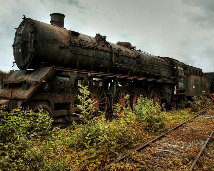 Rusty Abandoned Steam Locomotive by Overgrown Tracks