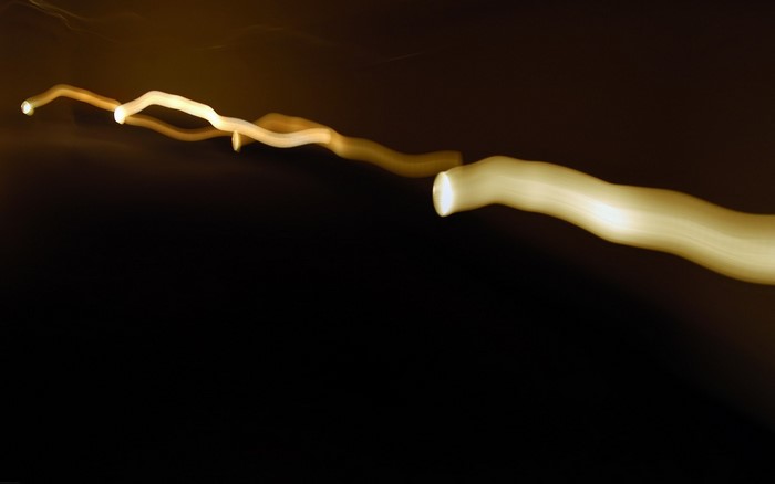 Abstract light painting with yellow streaks on black background