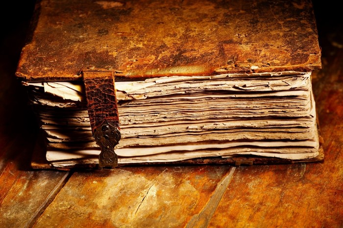 Old leather-bound book on a wooden table