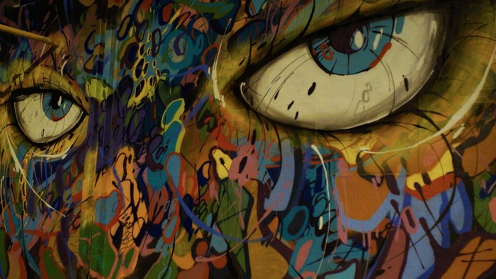Graffiti mural of a face with colorful abstract patterns