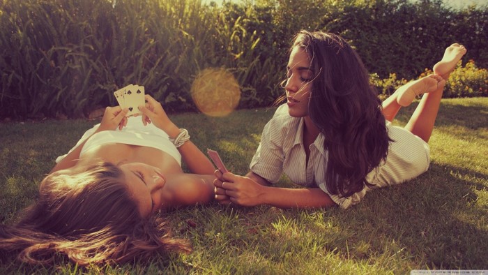 Two women playing cards outdoors