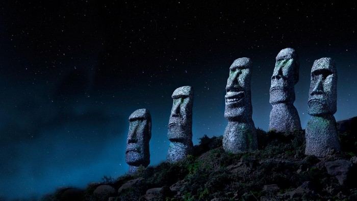 Moai statues under a starry night sky
