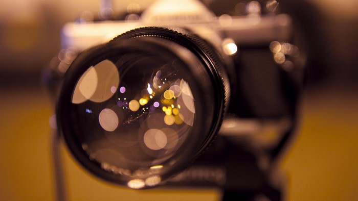 Close-up of a camera lens with bokeh lights