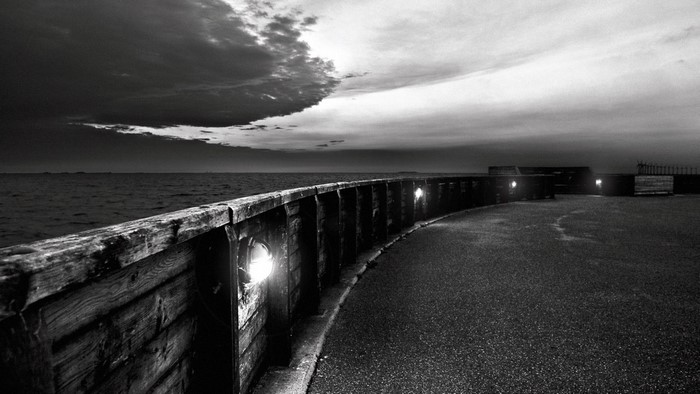 Monochrome view of a seaside promenade at dusk