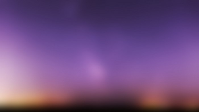 Blurred purple and orange sky with faint lights