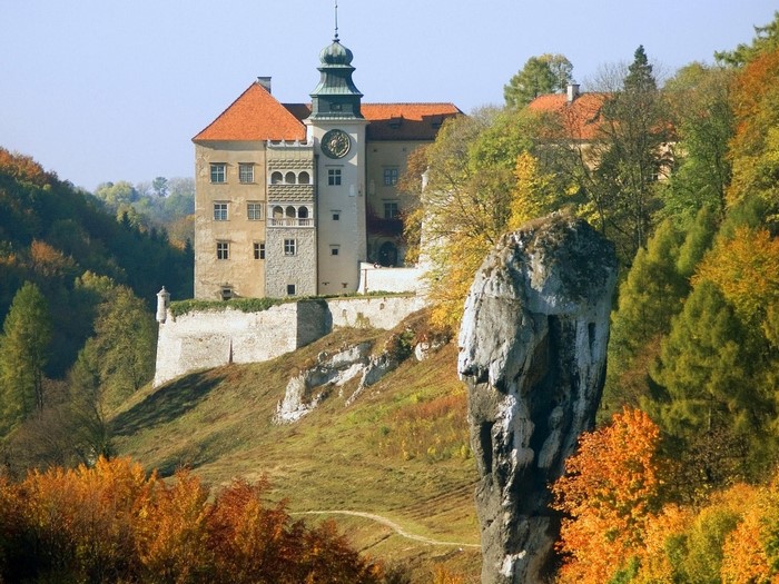 Castle on a hill with autumn trees and rock formation