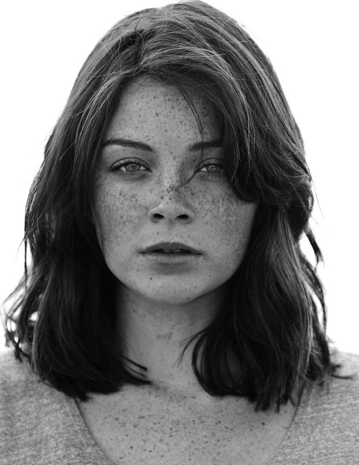 Monochrome portrait of a young woman with freckles