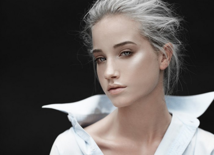 Model with platinum blonde hair wearing a white shirt