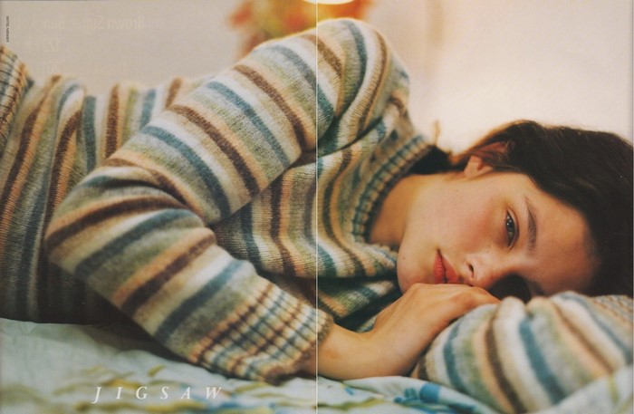 Young woman in striped sweater lying down