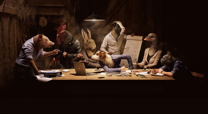 Animals in business attire meeting around a table