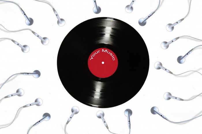 Vinyl record surrounded by earphones on a white background