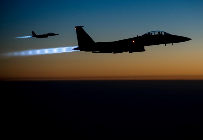 Two F-15 Eagle fighter jets flying at night