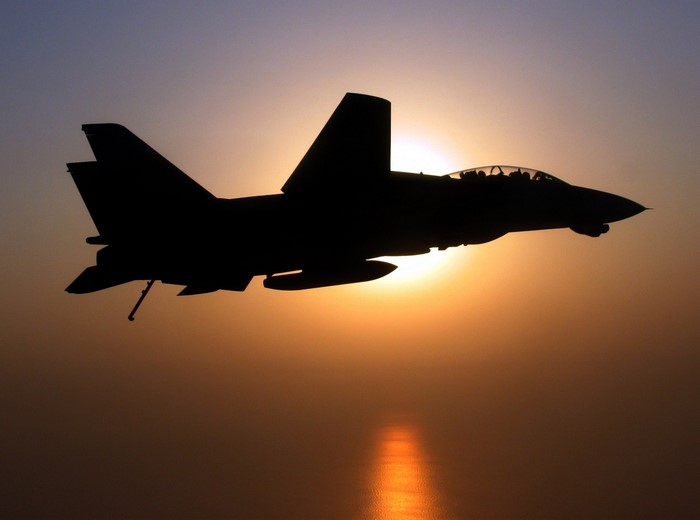 Silhouette of an F-14 Tomcat fighter jet at sunset