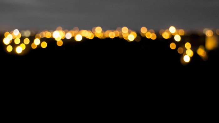 Bokeh lights at night over dark landscape