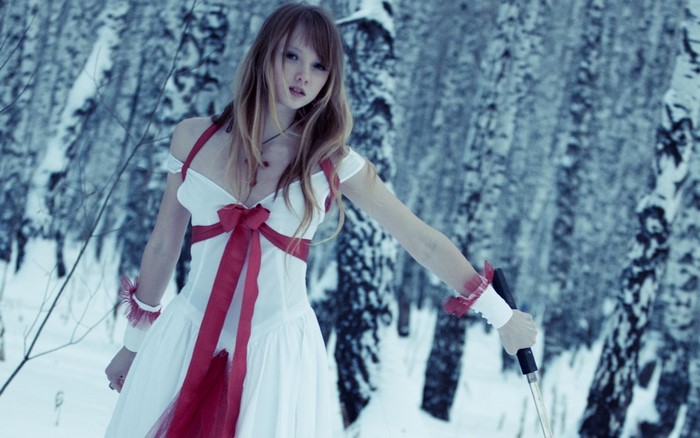 Woman in white and red dress in snowy forest
