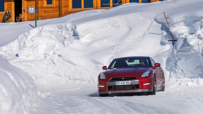 Red Nissan GT-R driving on a snowy road