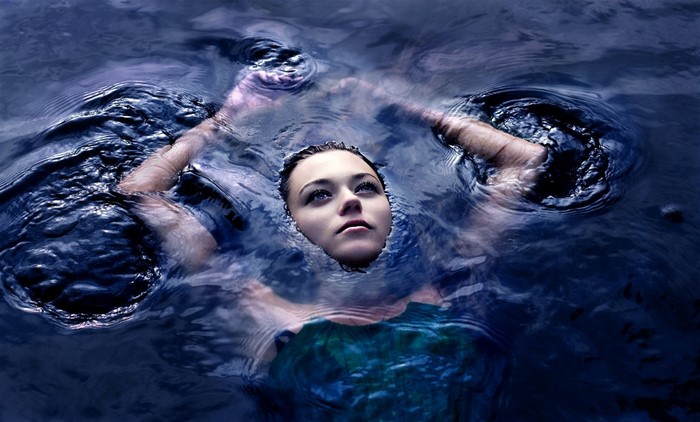 Woman submerged in dark blue water