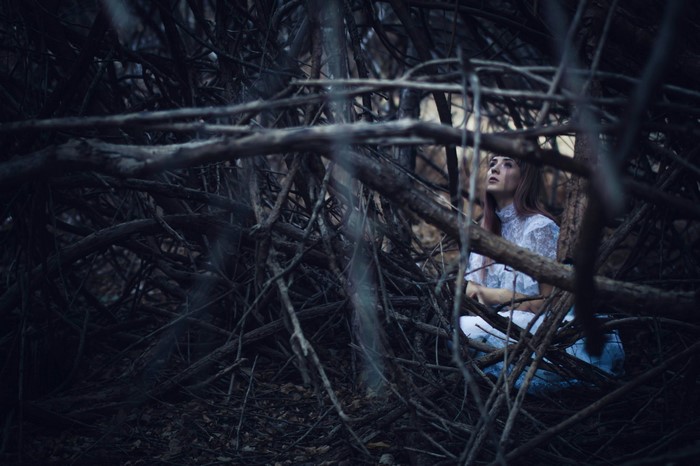 Woman in white dress in dark forest