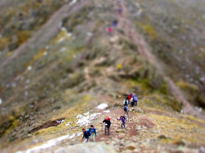 Hikers on a mountain trail with tilt-shift effect