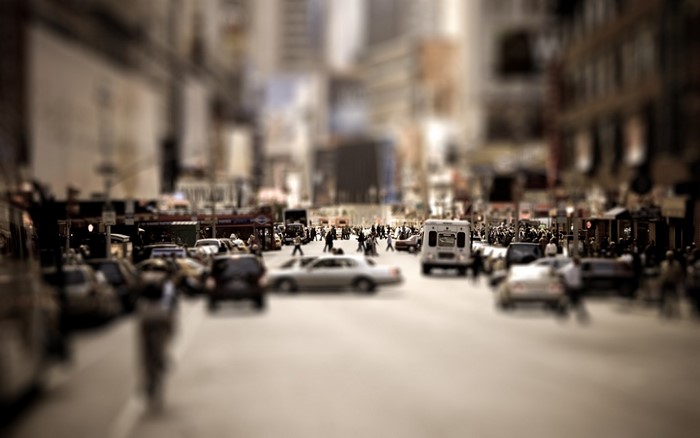 Tilt-shift cityscape with traffic and pedestrians