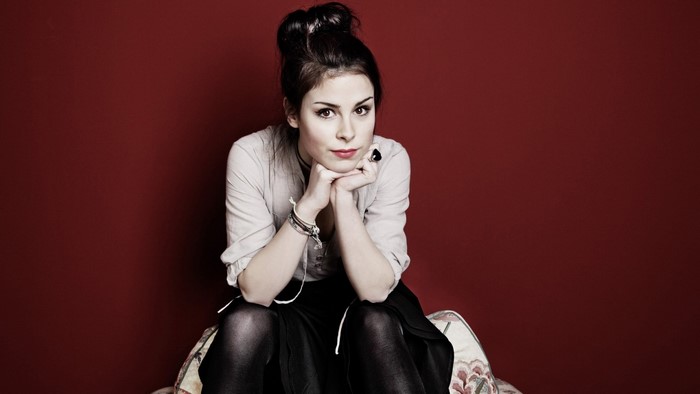 Lena Meyer Landrut posing against a red background