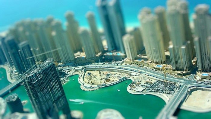 Aerial tilt-shift cityscape of Dubai skyscrapers and water