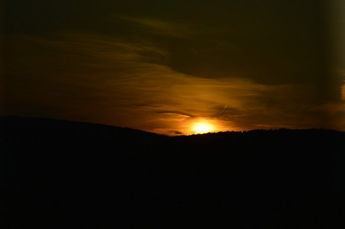 Sunset over a dark mountain silhouette