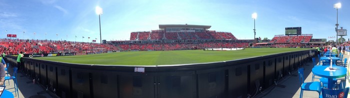 BMO Field soccer stadium with red seats and green field