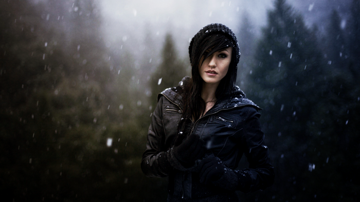 Woman in a black beanie and jacket in the snow