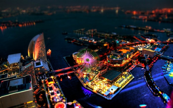 Cityscape at night with Ferris wheel and illuminated buildings