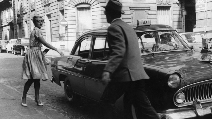 Woman hailing a taxi in Paris