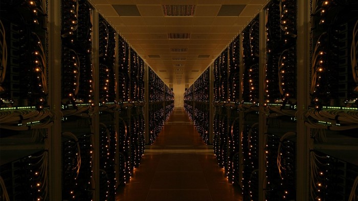 Server room hallway with rows of illuminated racks