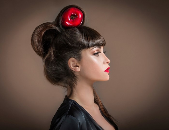 Woman with red apple in her hair