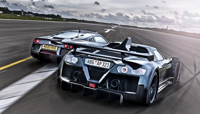 Two Gumpert Apollo sports cars racing on a track
