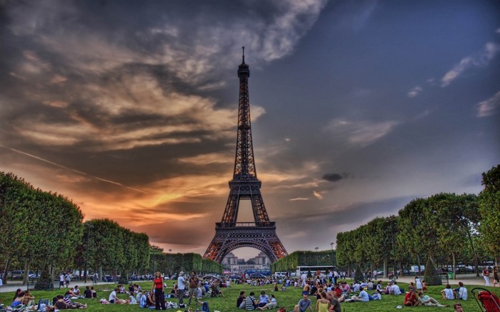 Eiffel Tower at dusk with people picnicking