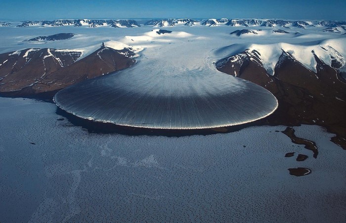 Glacier flowing into the Arctic Ocean with mountains