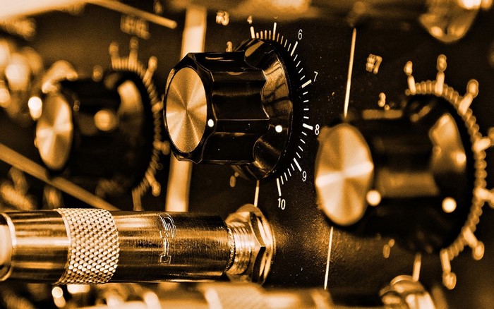 Close-up of audio equipment knobs and cable