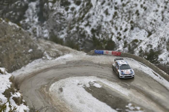 VW Polo WRC racing on a snowy mountain road