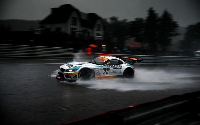 BMW Z4 GT3 race car driving on a wet race track