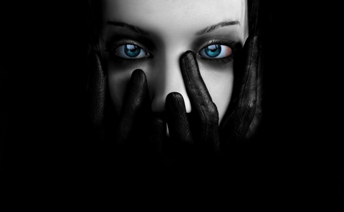 Close up of a person's face with hands covering it