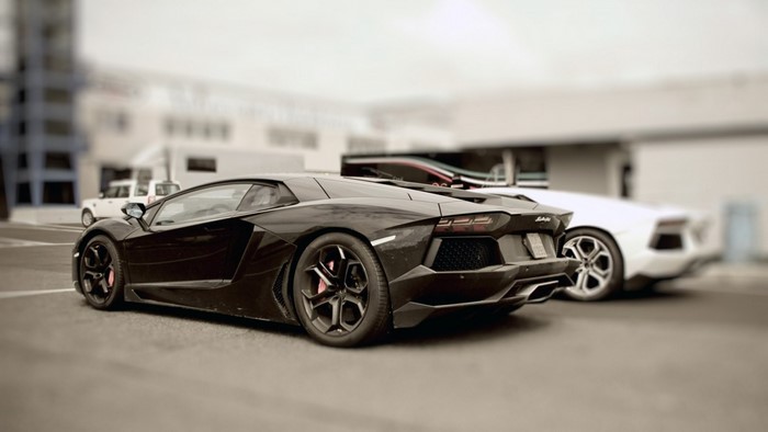 Black Lamborghini Aventador and white Lamborghini
