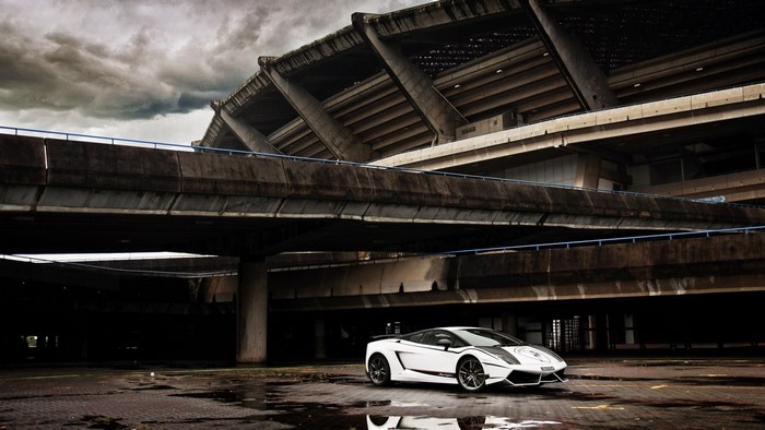 White Lamborghini Gallardo parked under a stadium overpass