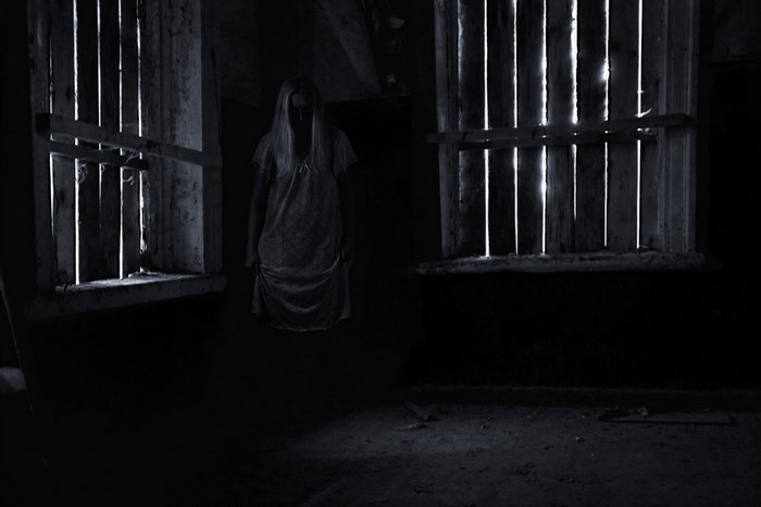 Woman in a nightgown in a dark room