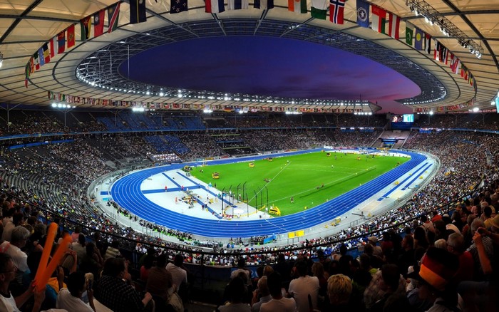 Olympic Stadium with Flags and Crowd at Dusk