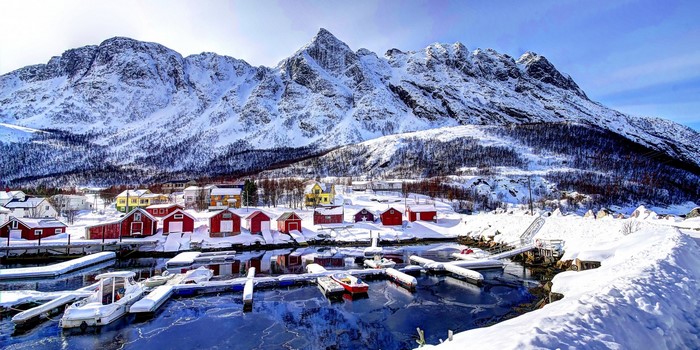 Snowy village with mountains and harbor in Norway