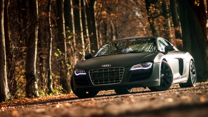 Matte black Audi R8 sports car on a forest road