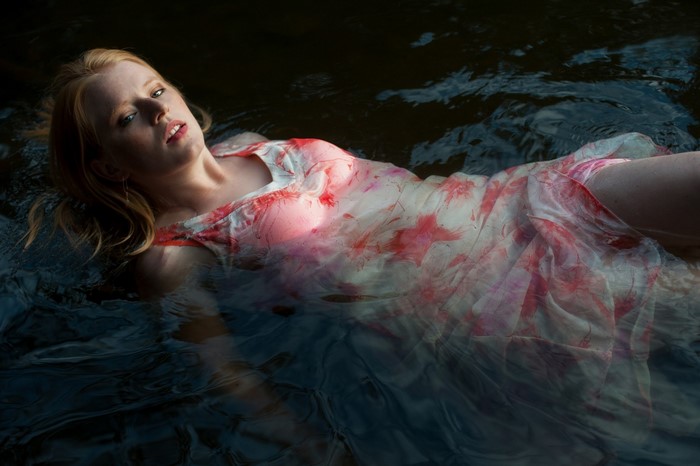 Woman in a floral dress floating in dark water